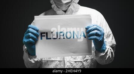Flurona, infection with both seasonal flu and Covid 19 coronavirus, conceptual image with epidemiologist holding white paper with text, selective focu Stock Photo