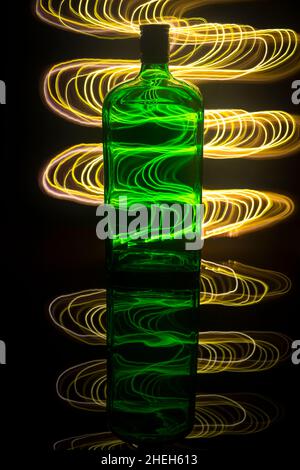 A green bottle on the background which is illuminated with light painting. Stock Photo