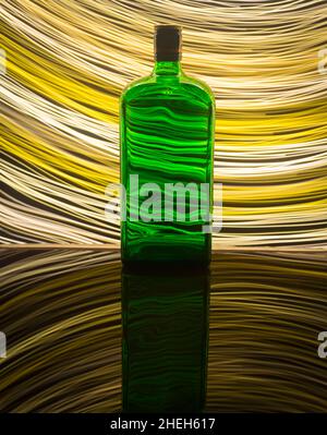 A green bottle on the background which is illuminated with light painting. Stock Photo