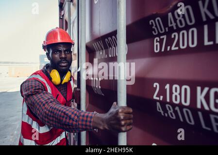 African-American  workers are opening containers for inspection and check that repairs have been completed in containers. Stock Photo