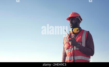 Close up Professional African-American male engineers use radio communication to communicate efficiently in industrial factories. Stock Photo