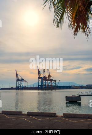Large cranes on one of the docks in the port of Malaga at sunset. Stock Photo