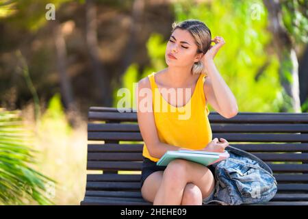Teenager student girl at outdoors having doubts Stock Photo