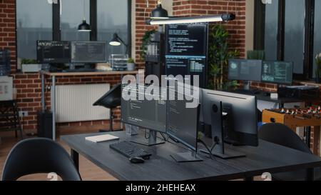 Computer screens running programming code in empty software it agency office and computers parsing data algorithms in background. Neural network servers cloud computing in data room. Stock Photo