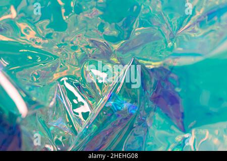 Turquoise blurred holographic background. Wrinkled foil surface. Defocused surreal texture. Stock Photo