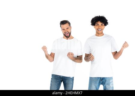cheerful man shouting and showing triumph gesture with young african american friend isolated on white Stock Photo