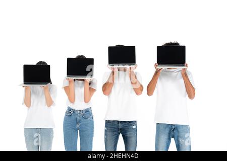multicultural friends in jeans and t-shirts obscuring faces with laptops with blank screen isolated on white Stock Photo