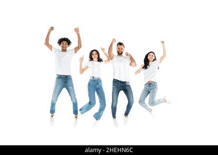 excited multiethnic friends in jeans looking at camera while levitating on white Stock Photo