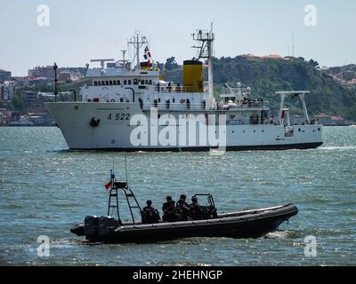 The Portuguese Navy survey ship D. Carlos I (A522) is closely guarded by members of the Maritime Police's Tactical Action Group on a high speed boat. Stock Photo