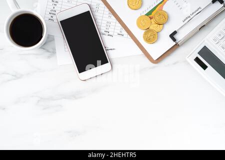 Top view of annual summary review concept with smart phone, report and office supply on marble white table background. Stock Photo