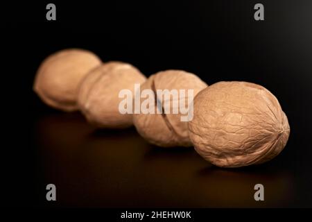 Walnuts on a black background in the shell close-up Stock Photo