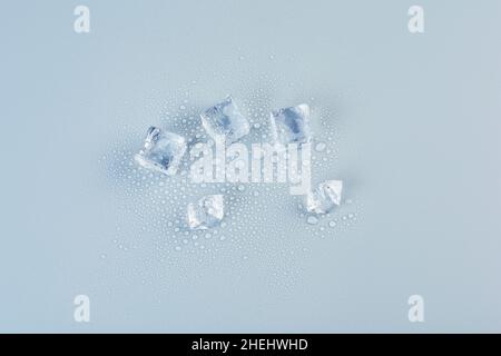 Five ice cubes on a gray background in the center Stock Photo