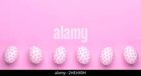 Easter background with paschal eggs, pastel pink template, greeting card with copy space for text. Springtime. Beautiful holiday banner. Flat lay, moc Stock Photo