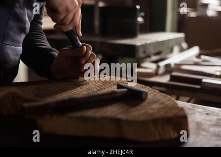 Young male carpenter, young male carpenter drilling holes in wood in his workshop Stock Photo