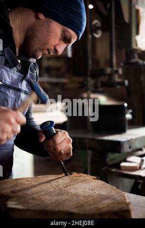 Young male carpenter, young male carpenter working in his workshop using tools Stock Photo