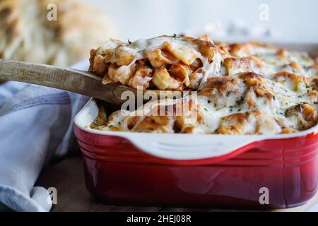 Spoonful of homemade backed tortellini noodle casserole topped with chopped fresh parsley and melted golden mozzarella cheese. Selective focus with bl Stock Photo