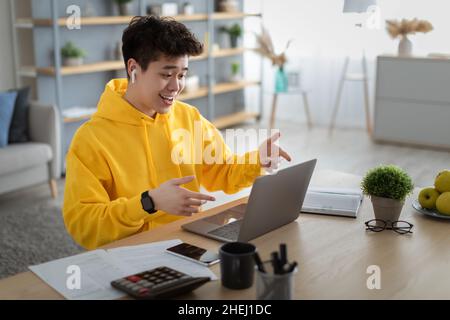 Smiling asian man using laptop making video call Stock Photo