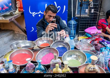 A Sand Artist Preparing Colourful Sand Bottles, Aqaba, Aqaba Governorate, Jordan. Stock Photo