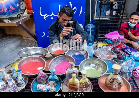 A Sand Artist Preparing Colourful Sand Bottles, Aqaba, Aqaba Governorate, Jordan. Stock Photo