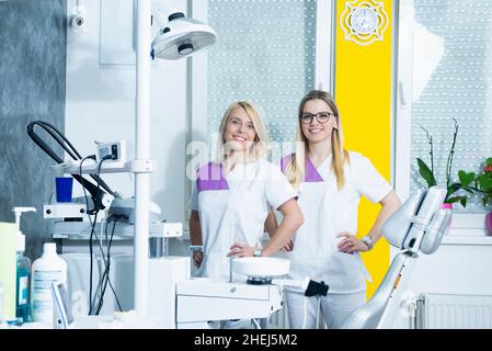 Team of two female doctors smiling in their dental office Stock Photo