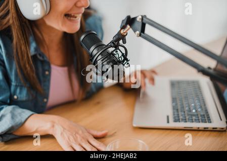 Woman in headphones recording podcast Stock Photo