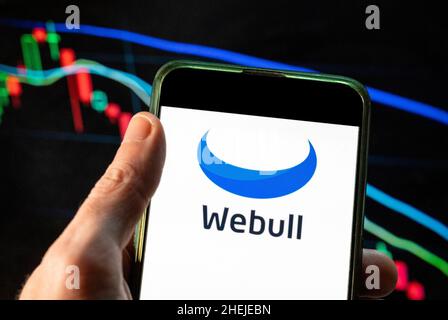 China. 4th Dec, 2021. In this photo illustration the financial trading services company Webull logo seen displayed on a smartphone with an economic stock exchange index graph in the background. (Credit Image: © Budrul Chukrut/SOPA Images via ZUMA Press Wire) Stock Photo