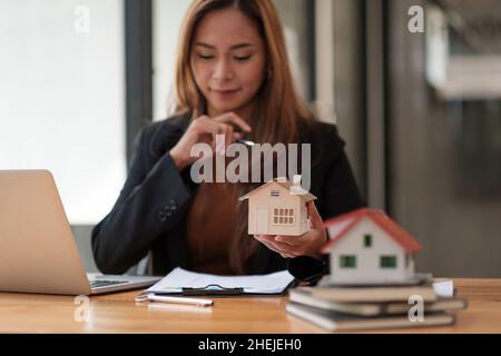 Business Financing Accounting Banking Concept, businesswoman doing finances and calculate about cost to real estate investment and tax Stock Photo