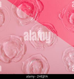 Transparent swatch gel texture on color pink background. Skincare cosmetic product texture of collagen or hyaluron liquid serum. Circle swatch made Stock Photo