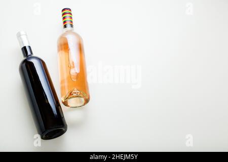 Red wine bottle and rose wine bottle. Minimalistic wine composition top view on white background copy space. Wine brand mockup template. Stock Photo