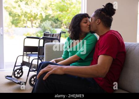 African american couple kissing while sitting on the couch at home Stock Photo