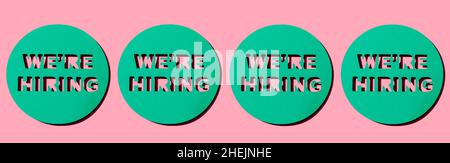 four round-shaped mint green pieces of paper with the text we are hiring cut out on them, on a light pink background, in a panoramic format to use as Stock Photo
