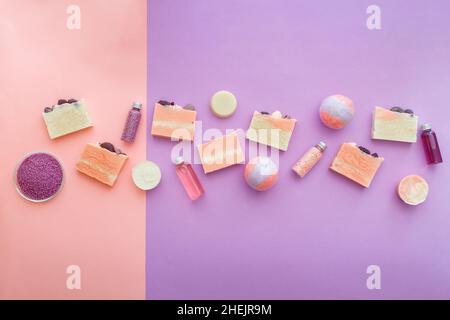 Natural handmade pink colorful soap, spa beauty cosmetic products pattern on purple background. Aromatherapy soap for body skincare wellness bomb Stock Photo