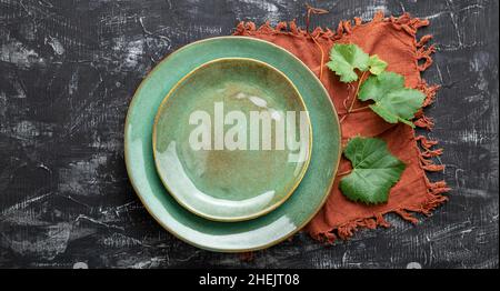 Empty green plate served with grape leaf plant table napkin. Mockup template plate for luxury dinner in wine restaurant with Mediterranean cuisine Stock Photo