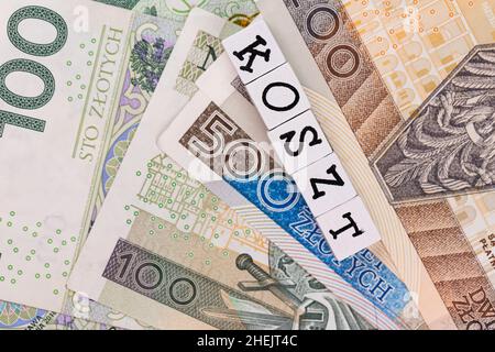 The wording 'Koszt' translated as 'Cost' and many Polish banknotes. New taxation rules in Poland. Photo taken under artificial, soft light Stock Photo