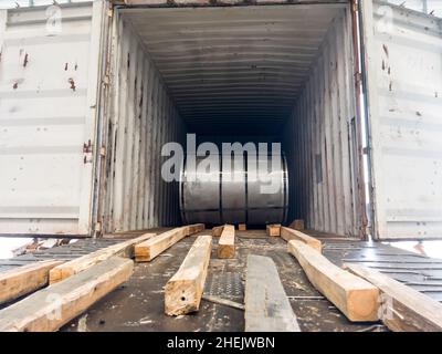 Loading master coil steel out of container Stock Photo - Alamy