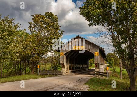 The Caine Road Covered Bridge crosses the Ashtabula River during the Autumn leaf color change in Ashtabula County, Ohio. Stock Photo