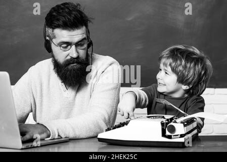 Back to school. Young boy doing his school homework with his father. Teacher helping kids with their homework in classroom at school. Preschool pupil Stock Photo