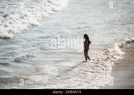 A person entering the sea from Praia da Paciencia in Salvador, Bahia, Brazil. Stock Photo