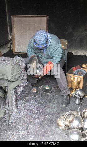 Ushaiqer, Saudi Arabia, 1st January 2022: man working in a dusty workshop, making arabic coffee pots Stock Photo