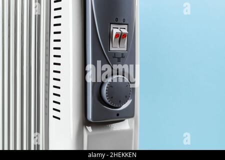 Front panel with thermostat knob and two switches of oil filled electric  heater against blue background. Portable domestic appliance for home  heating Stock Photo - Alamy
