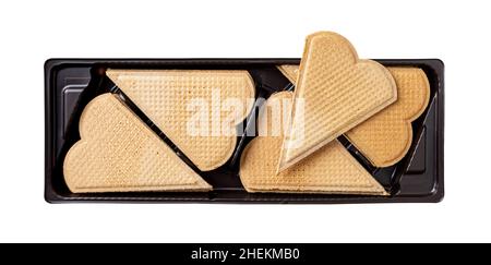 Heart shaped wafers for garnishing in a black plastic container isolated on a white background. Thin flat waffle biscuits for ice cream decoration. Stock Photo