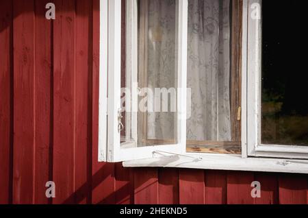 Symbolic image: Window detail of a wooden house in the style of a typical Swedish wooden hut. Stock Photo