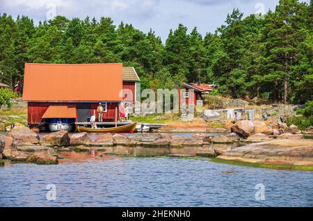 Picturesque scenery with boatsheds and wooden cottages in typical Swedish red on the edge of the Småland archipelago near Oskarshamn, Sweden. Stock Photo