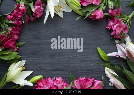 Frame of Easter flowers on a dark wood background with copy space Stock Photo