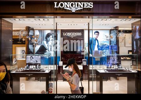 A shopper walks past the Swiss luxury watchmaker brand Longines