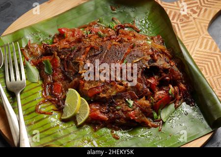 Meen Pollichathu or fish pollichathu, tasty kerala dish, fish with masala cooked in banana leaf. Stock Photo