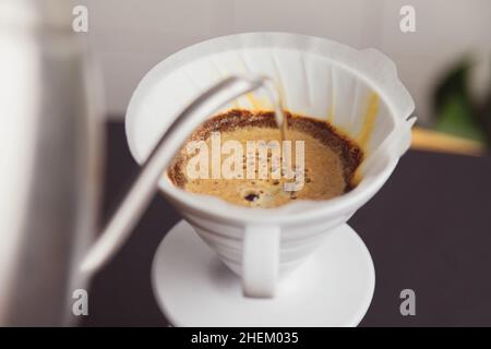 Barista pours ground coffee to aeropress Stock Photo by bublikhaus