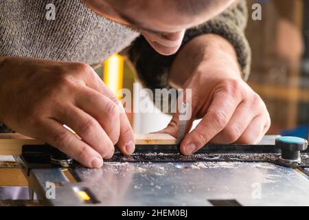 Closeup of unrecognizable carpenter cutting wood using disksaw in joinery workshop, copy space Stock Photo