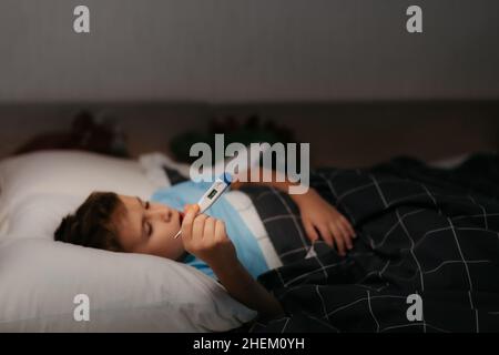 small child shows thermometer with high temperature. Focus on the thermometer. Stock Photo