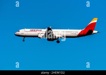 Madrid, Spain - December 31, 2021: Airbus A321 passenger aircraft of the Spanish airline Iberia flying before landing against the clear blue sky. Stock Photo